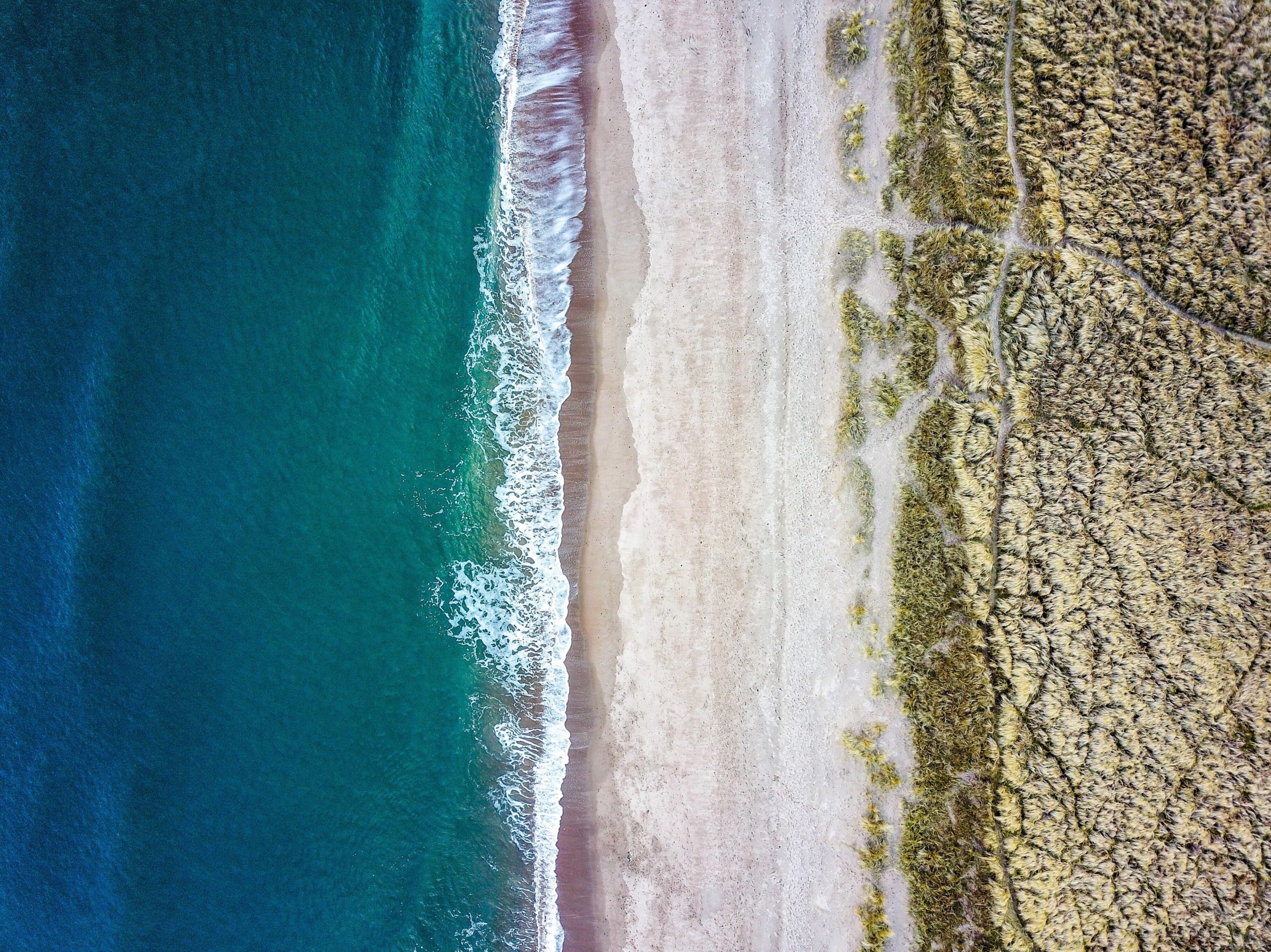 Top view of waves crashing on a deserted beach